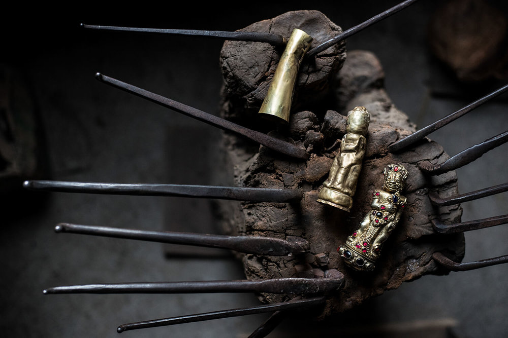  Three stages of&nbsp; repoussé work show a bare brass cylinder, a work in progress, and a finished&nbsp; raksasa  handle. 